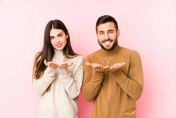 Jovem Casal Caucasiano Isolado Segurando Algo Com Palmas Das Mãos — Fotografia de Stock