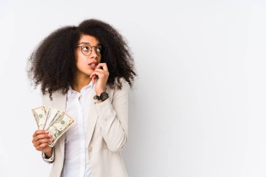 Kredi kartı tutan genç afro iş kadını elinde kredi kartıyla gezen genç afro iş kadını fotokopi odasına bakan bir şeyi düşünerek kendini soyutladı..