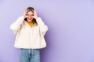 Mor arka planda izole edilmiş beyaz bir kadın, gözlerde sorun olmadığını gösteriyor.