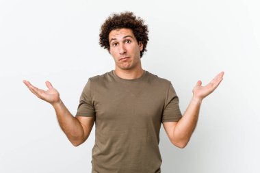 Olgun, yakışıklı bir adam. Kafası karışmış ve omuz silkiyor. Kopya alanını tutmak için..