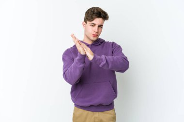 Beyaz arka planda izole olmuş genç beyaz bir adam enerjik ve rahat hissediyor, ellerini ovuşturuyor..