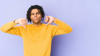 Rasta saç stili giymiş, hoşlanmadığı bir jest yapan genç bir zenci. Anlaşmazlık konsepti.