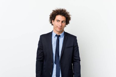 Genç iş adamı beyaz arka plana karşı şaşkın, kuşkulu ve güvensiz hissediyor.