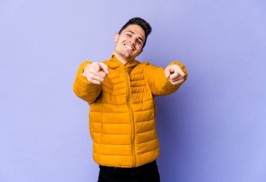 Mor arka planda izole edilmiş genç beyaz adam öne bakan neşeli gülücükler.