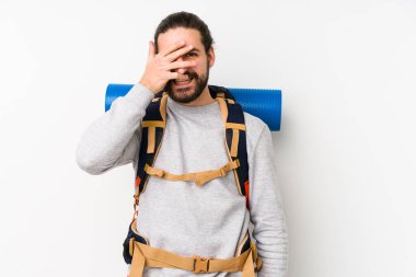 Sırt çantalı genç adam beyaz bir arka planda izole edildi. Kameraya parmaklarıyla göz kırptı. Yüzünü kapatmaktan utanıyordu..