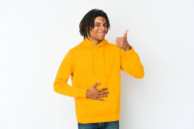 Genç Afrikalı Amerikalı Rasta adam karnına dokunuyor, nazikçe gülümsüyor, yemek yiyor ve tatmin oluyor..