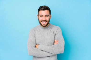 Mavi bir arka planı olan beyaz bir genç adam gülüyor ve eğleniyor..