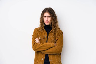 Uzun saçlı adam kameraya bakıp alaycı bir ifadeyle mutsuz poz veriyor..