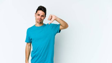 Beyaz arka planda izole edilmiş genç beyaz adam baş parmağını aşağı gösteriyor, hayal kırıklığı konsepti..