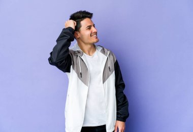 Mor arka planda izole edilmiş genç beyaz bir adam zaferi, tutkuyu ve coşkuyu kutluyor, mutlu bir ifade..