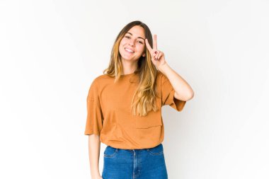 Beyaz arka planda izole edilmiş genç beyaz kadın iki numarayı parmaklarıyla gösteriyor..
