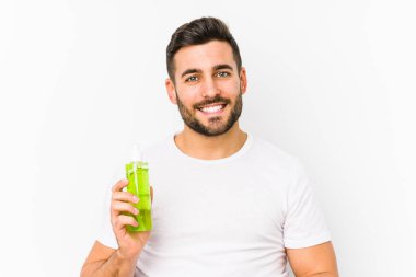 Genç, beyaz bir adam elinde aloe vera ile nemlendirici tutuyordu izole edilmiş, kollarını kavuşturarak gülümsüyordu..