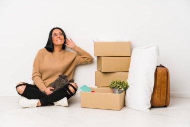 Beyaz arka planda izole bir şekilde evine taşınan kadın bir dedikoduyu dinlemeye çalışıyor..