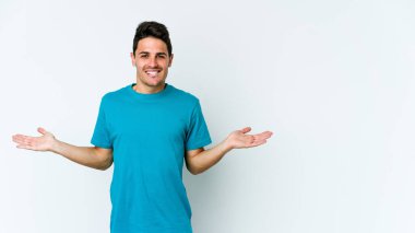 Beyaz arka planda izole edilmiş genç beyaz bir adam. Kafası karışmış ve omuz silkiyor. Kopya alanını tutmak için..