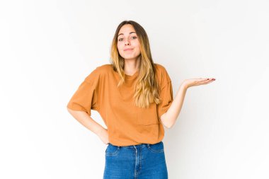 Beyaz arka planda soyutlanmış beyaz bir kadın sorgulama sırasında omuz silkiyor ve şüphe duyuyor..