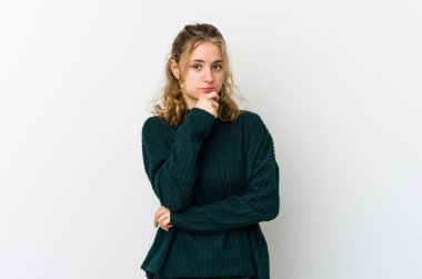 Beyaz arka plandaki genç beyaz kadın şüpheli, belirsiz, seni muayene ediyor..