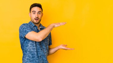 Sarı fırında izole edilmiş genç beyaz adam elleri arasında bir kopya alanı tutarken şok ve hayrete düştü..