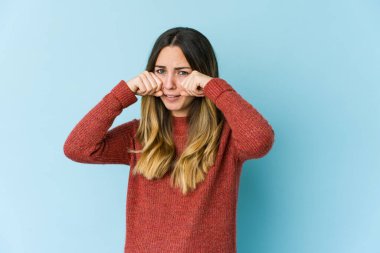 Beyaz bir kadın mavi arka planda yalnız başına sızlanıyor ve ağlıyordu..