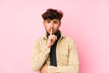 Arka planda poz veren genç bir Arap bir sır saklıyor ya da sessizlik istiyor..