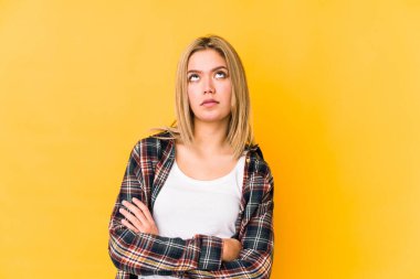 Sarışın, beyaz bir kadın. Sarı arka planda izole edilmiş. Tekrarlanan bir görevden yorulmuş..