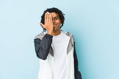 Genç Afro-Amerikan sporcusu yüzünün yarısını avuç içiyle örterek eğleniyor..