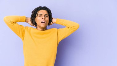 Rasta saç stili giyen genç bir adam çığlık atıyor, çok heyecanlı, tutkulu, bir şeyden memnun..