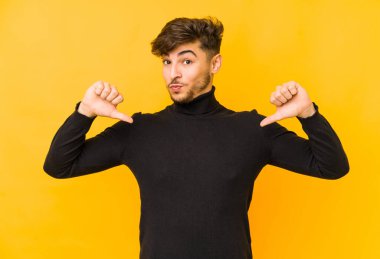 Sarı arka planda izole edilmiş genç bir Arap gururlu ve kendinden emin hissediyor, örnek olarak.