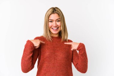 Sarışın, beyaz tenli, izole bir kadın. Parmakla işaret ederek şaşırmış, gülümseyerek..