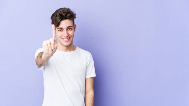 Mor arka planda izole genç beyaz adam parmak ile bir numara gösteriyor.