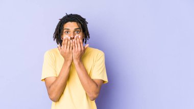 Genç Afrikalı Amerikalı Rasta adam elleriyle ağzını kapatırken şok oldu..