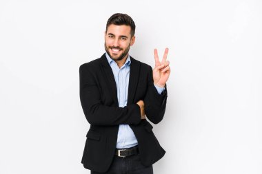 Beyaz arka planda beyaz tenli genç beyaz iş adamı iki numarayı parmaklarıyla gösteriyor..