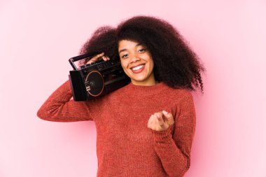 Elinde kaset tutan genç bir afro kadın seni işaret ediyor. Sanki davet ediliyormuş gibi..