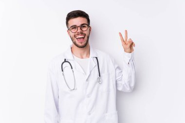 Kafkasyalı genç doktor neşeli ve kaygısız bir şekilde parmaklarıyla barış sembolü gösterdi..