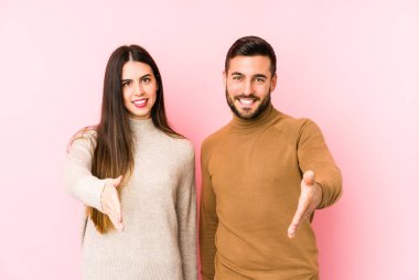 Beyaz tenli genç çift kameraya el ele tutuşup selamlaşıyorlar..