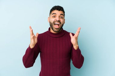 Genç, melez Arap bir adam zaferi ya da başarıyı kutluyor, şaşırıyor ve şok oluyor..