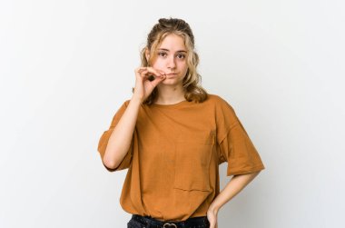 Beyaz arka planda beyaz tenli genç bir kadın parmakları dudaklarında bir sır saklıyor..