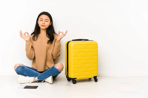 若いです中国人旅行者女性座っています床にスーツケース隔離されたリラックスハード作業日後 彼女はヨガを実行しています — ストック写真