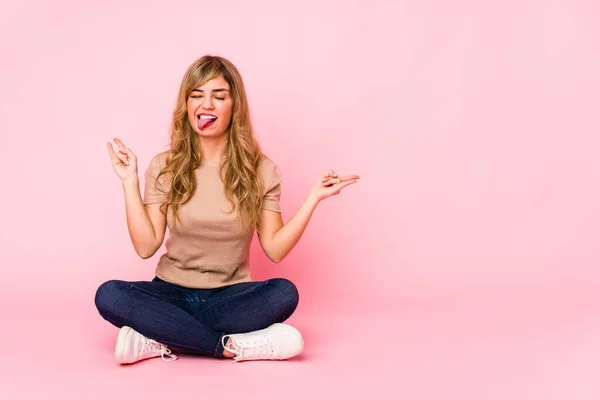 Jovem Loira Caucasiana Sentada Estúdio Rosa Mostrando Gesto Rock Com — Fotografia de Stock