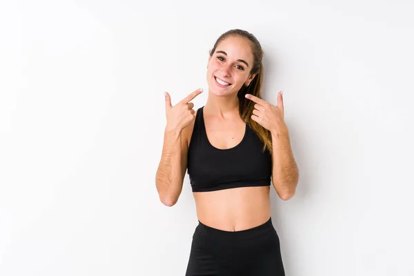 Joven Mujer Atlética Caucásica Posando Fondo Blanco Sonríe Señalando Con —  Fotos de Stock