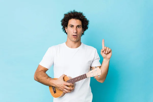 Young Caucasian Curly Man Playing Ukelele Having Some Great Idea — Stock Photo, Image