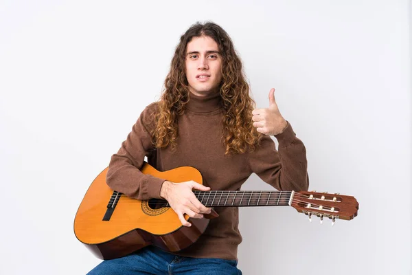年轻的高加索人弹奏吉他时 孤独地微笑着 竖起大拇指 — 图库照片