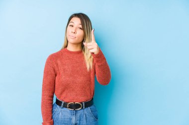 Genç beyaz kadın izole edilmiş poz veriyor. Bir numarayı parmağıyla gösteriyor..