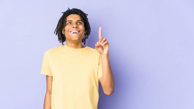 Genç Afro-Amerikalı Rasta adam iki parmağını da havaya kaldırarak boş bir alan gösterdiğini söylüyor..