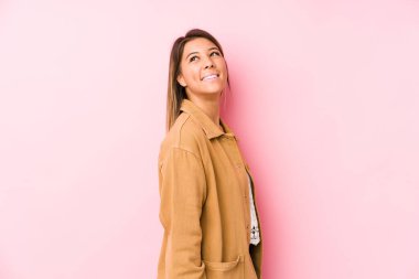 Kafkasyalı genç bir kadın yalnız poz veriyor. Gülümsüyor, neşeli ve keyifli görünüyor..