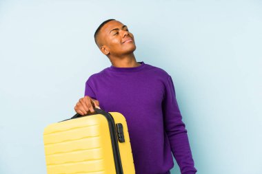 Genç gezgin bir bavul tutuyor. Amaçlarına ve amaçlarına ulaşmayı hayal ediyor.