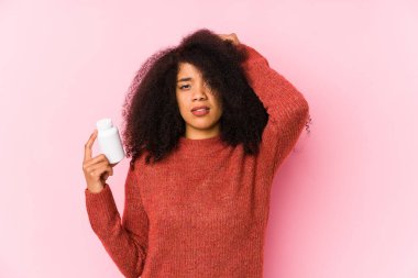 Vitaminlerini tutan genç afro kadın elinde vitaminlerle şoka giren genç afro kadın önemli bir toplantıyı hatırladı..