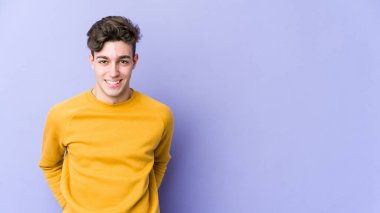 Mor arka planda izole edilmiş genç beyaz adam mutlu, güler yüzlü ve neşeli..