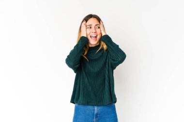 Beyaz arka planda izole edilmiş genç beyaz bir kadın. Kulakları kulaklarıyla kapatıyor. Çok fazla ses duymamaya çalışıyor..