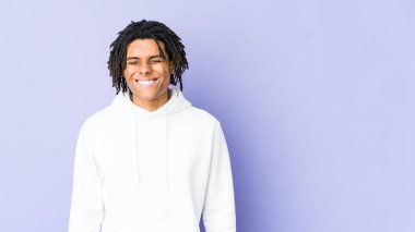 Genç Afrikalı Amerikalı Rasta adam gülüyor ve gözlerini kapıyor, rahatlamış ve mutlu hissediyor..