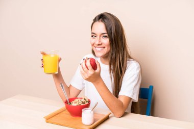 Genç beyaz kadın kahvaltı yapıyor.